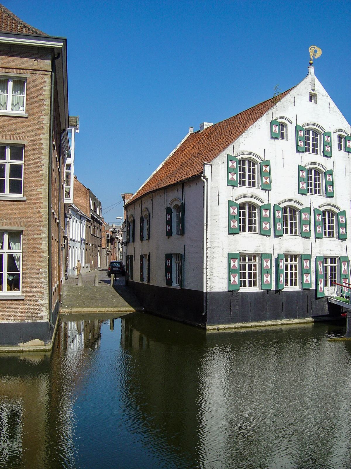 Wit huis met groene luiken aan het water in het centrum van Lier